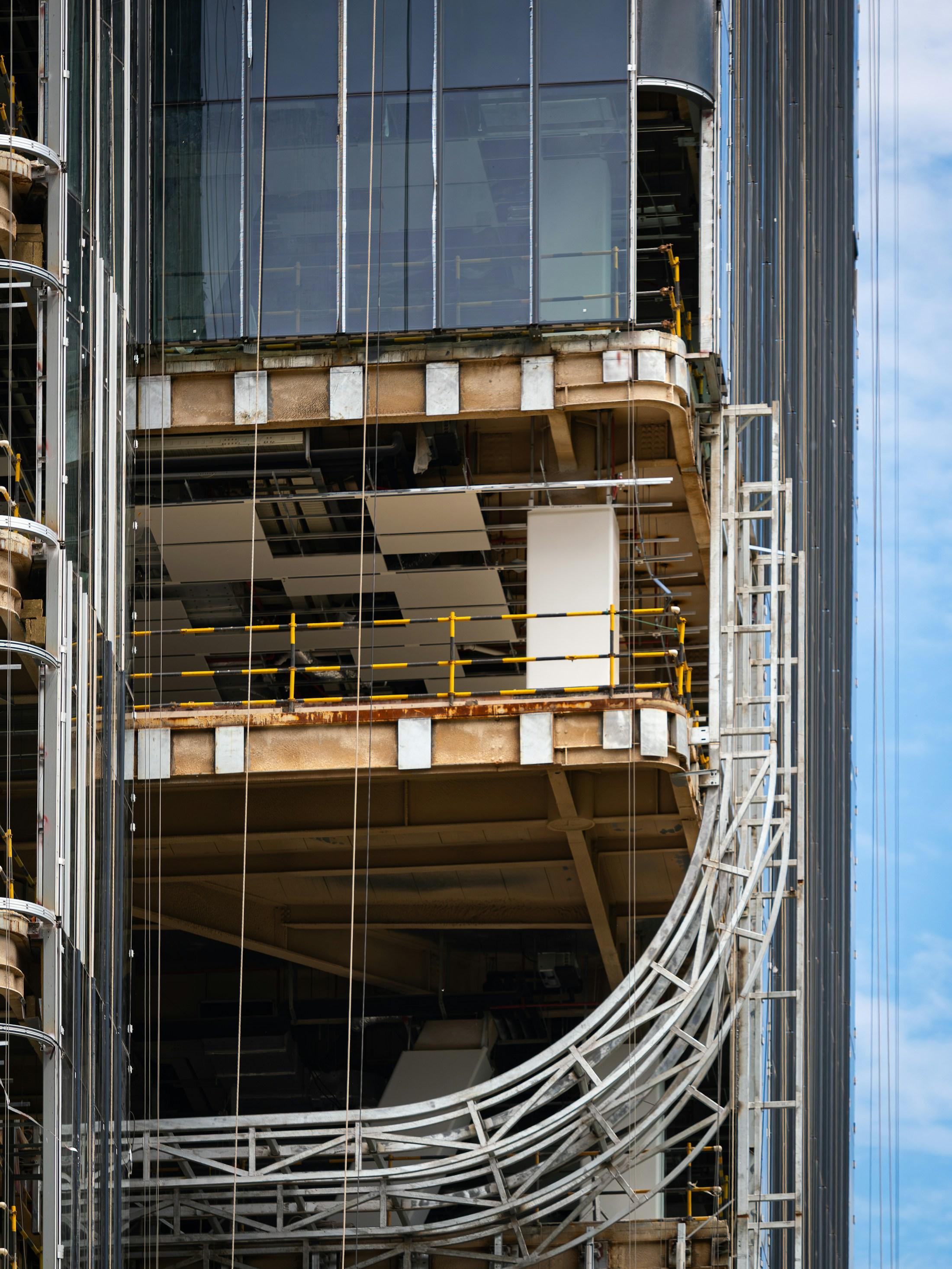 A contemporary facade under construction in a dense city setting